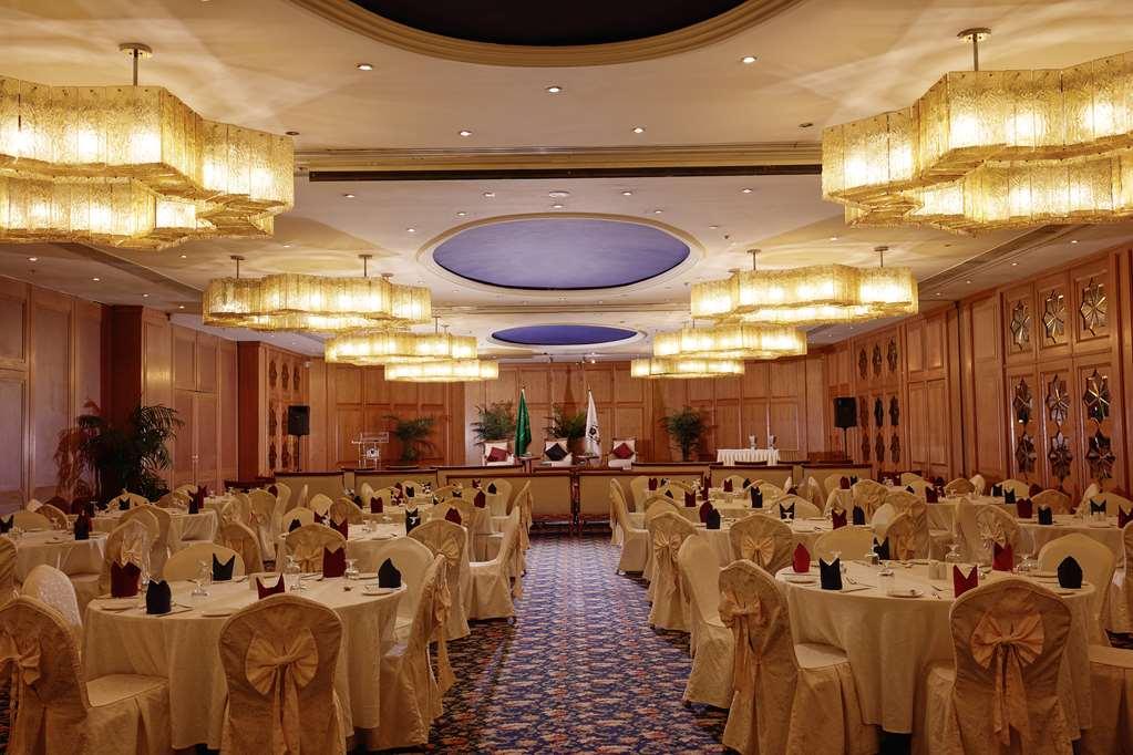 Makarem Ajyad Makkah Hotel Мекка Удобства фото The photo shows an elegantly arranged banquet or conference room. There are several round tables covered with light-colored tablecloths and adorned with decorative napkins. The seating is also stylish, with chairs featuring matching coverings. The ro