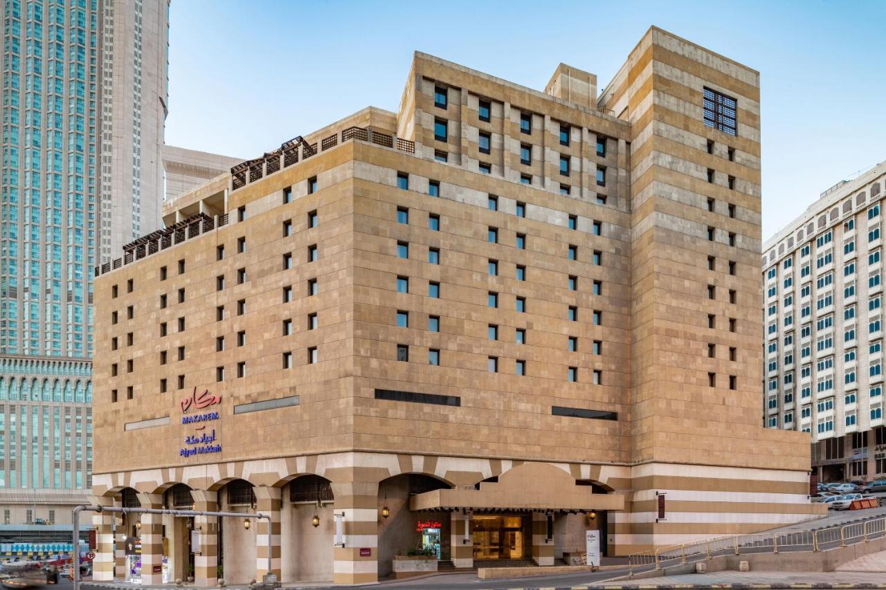 Makarem Ajyad Makkah Hotel Мекка Экстерьер фото The photo shows a multi-story building with a distinctive architectural style. The facade features a combination of textured stone and concrete, giving it a contemporary yet somewhat traditional appearance. The building has multiple windows arranged 